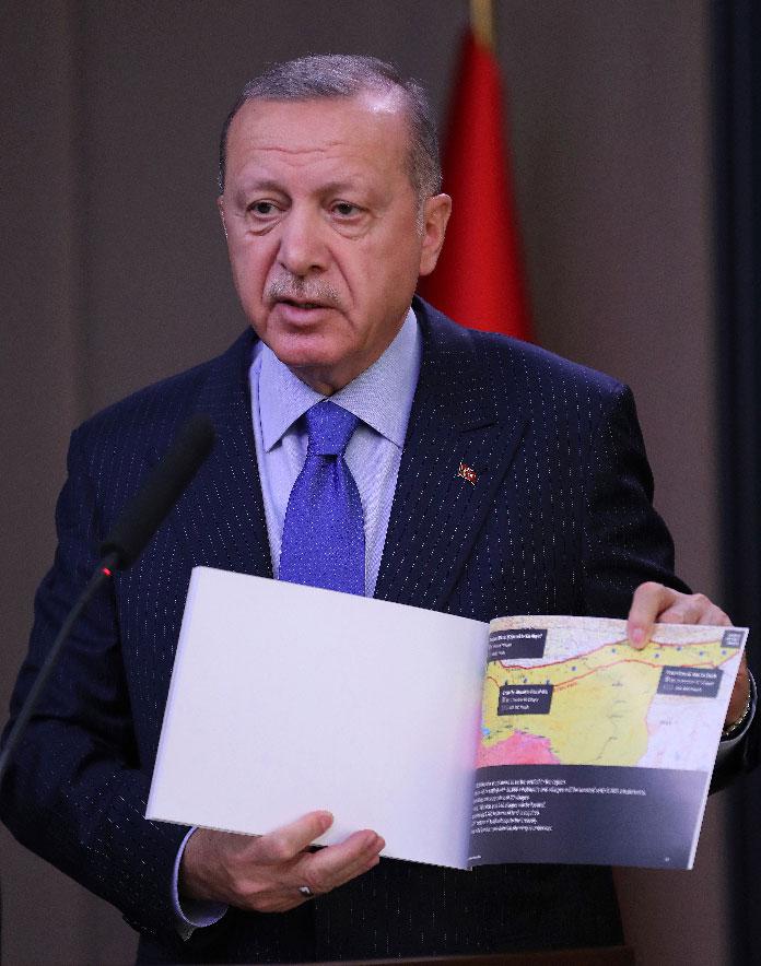 Turkish President Recep Tayyip Erdogan shows a document with a map of Turkey-Syria border 