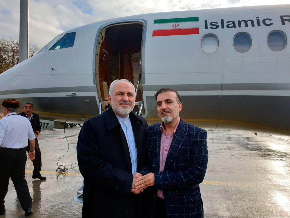Iran's Foreign Minister Mohammad Javad Zarif shakes hands with scientist Massoud Soleimani
