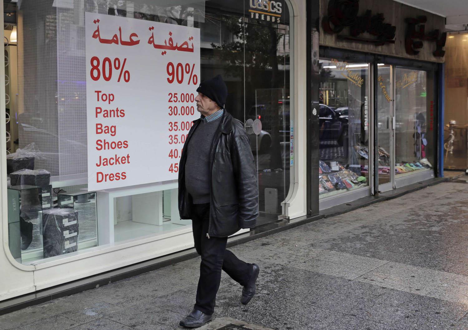 لبناني يمر بجانب محل يعرض تنزيلات وسط بيروت