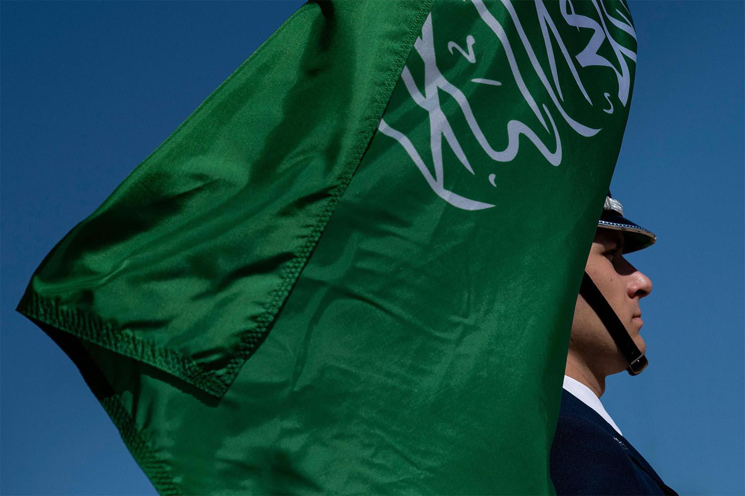 A color guard holds Saudi Arabia's flag 