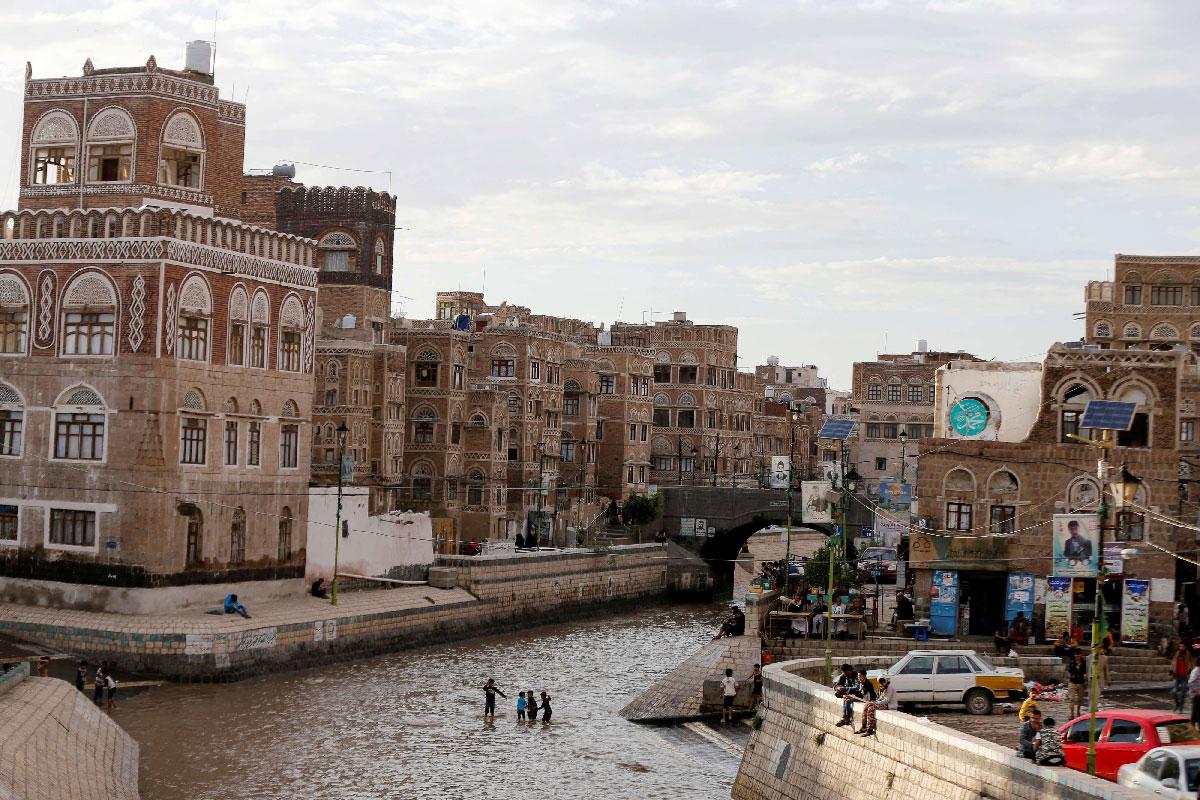 Boys play on a floodway following heavy rains in the old quarter of Sanaa