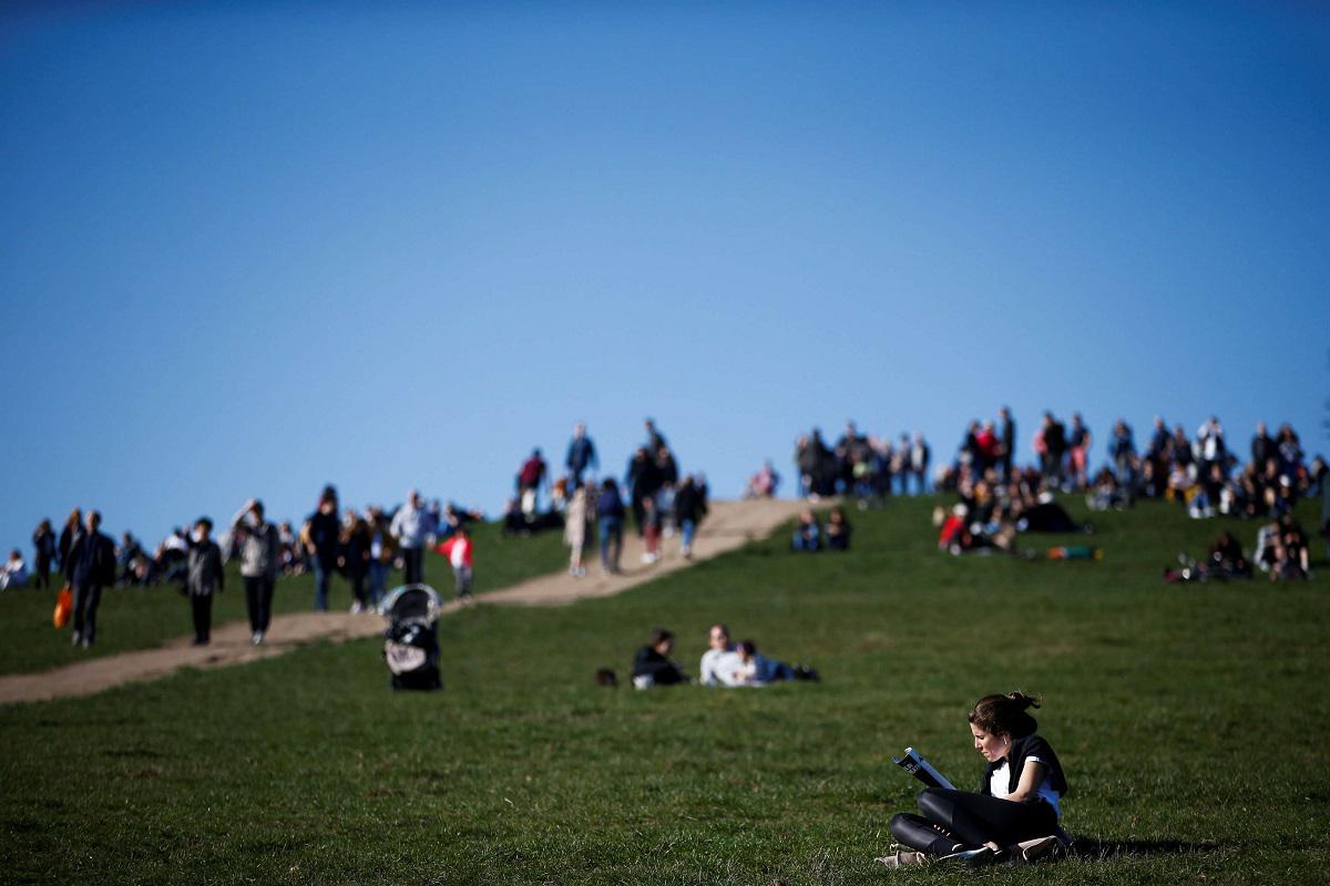 سيدة تقرأ كتابا في حديقة بلندن