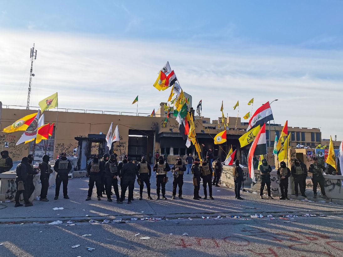 Protesters and militia fighters gather outside the US embassy in Baghdad