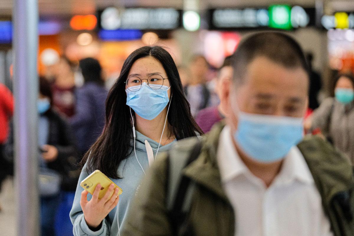Travellers wear surgical mask at the departure hall of the West Kowloon Rail station in Hong Kong