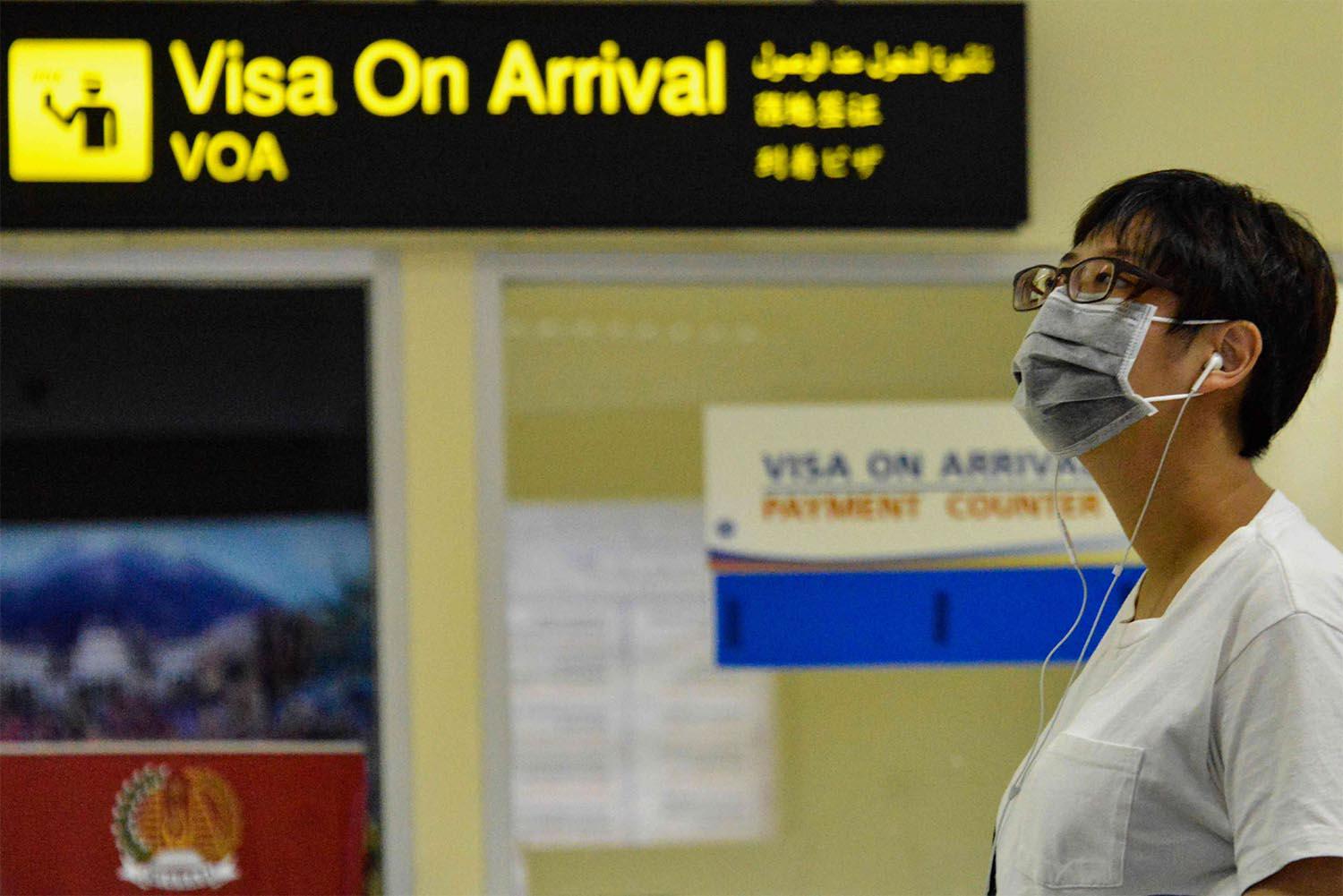 A passenger wearing a facemask to help stop the spread of a deadly virus which began in the Chinese city of Wuhan