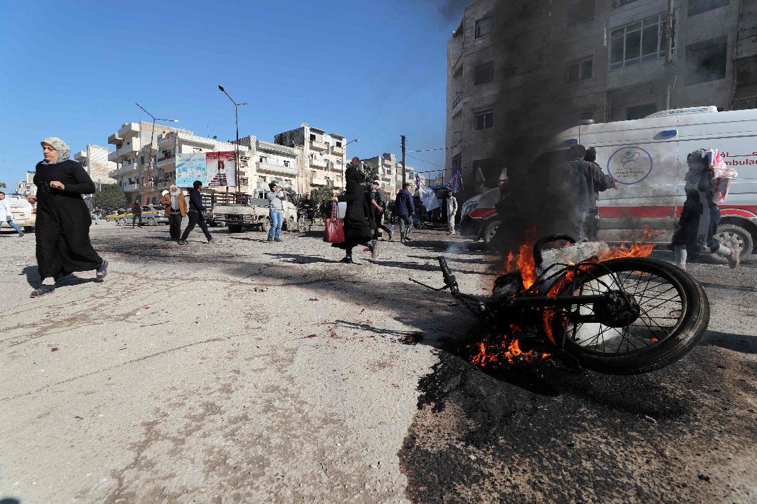 Panicked residents run following an air strike by pro-regime forces in the nothwestern Syrian city of Idlib