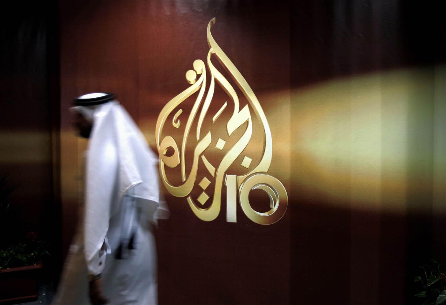 قطري يمر بجانب جدارية تحمل اسم قناة الجزيرة