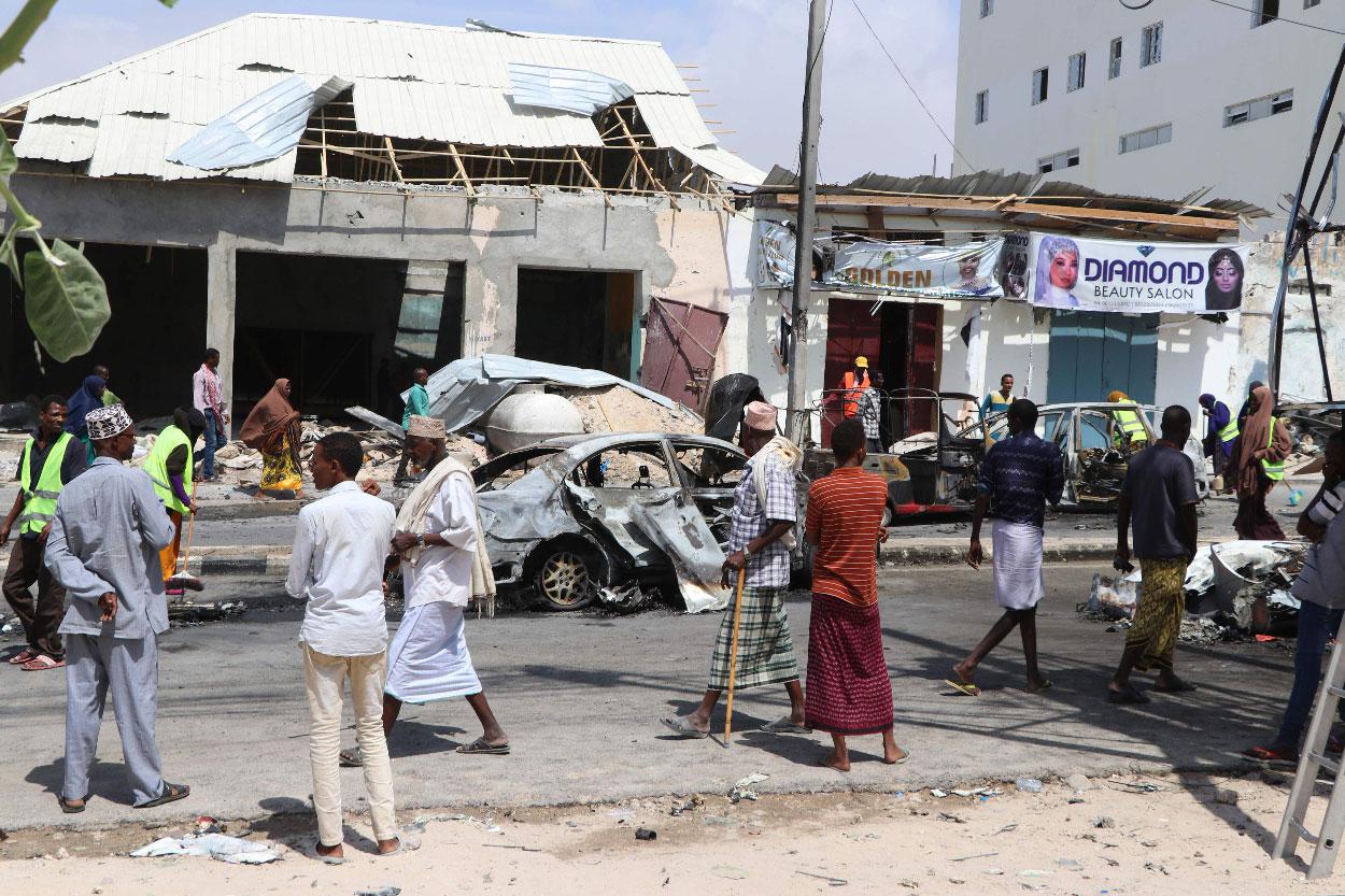 People gather at the site where a car bomb exploded near the Somali parliament in Mogadishu