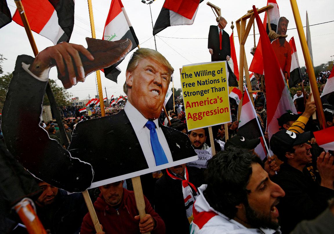 Supporters of Iraqi Shi'ite cleric Moqtada al-Sadr carry placards depicting US President Donald Trump