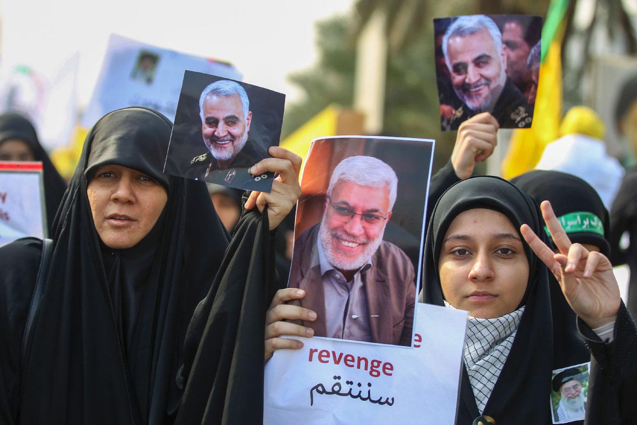 Iraqi women attend the funeral of Iranian military commander Qassem Soleimani (portrait), Iraqi paramilitary chief Abu Mahdi al-Muhandis (portrait) and eight others in Baghdad