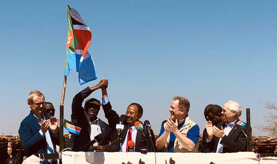 Sudanese PM Abdallah Hamdok clasps hands with rebel leader Abdelaziz al-Hilu in Kauda