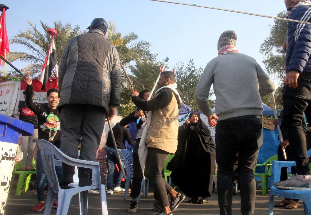 Iraqi anti-government protesters celebrate outside their protest tents in Baghdad's Tahrir Square following news of the killing of Qassem Soleimani