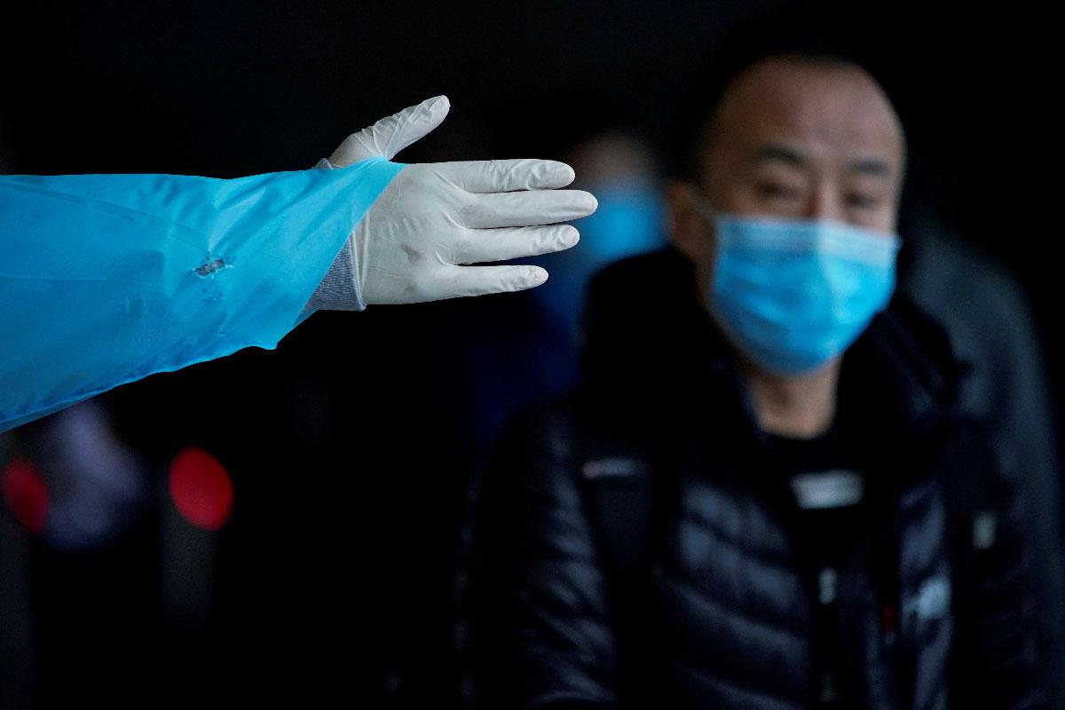 A passenger wearing a mask walks outside the Shanghai railway station in Shanghai, China