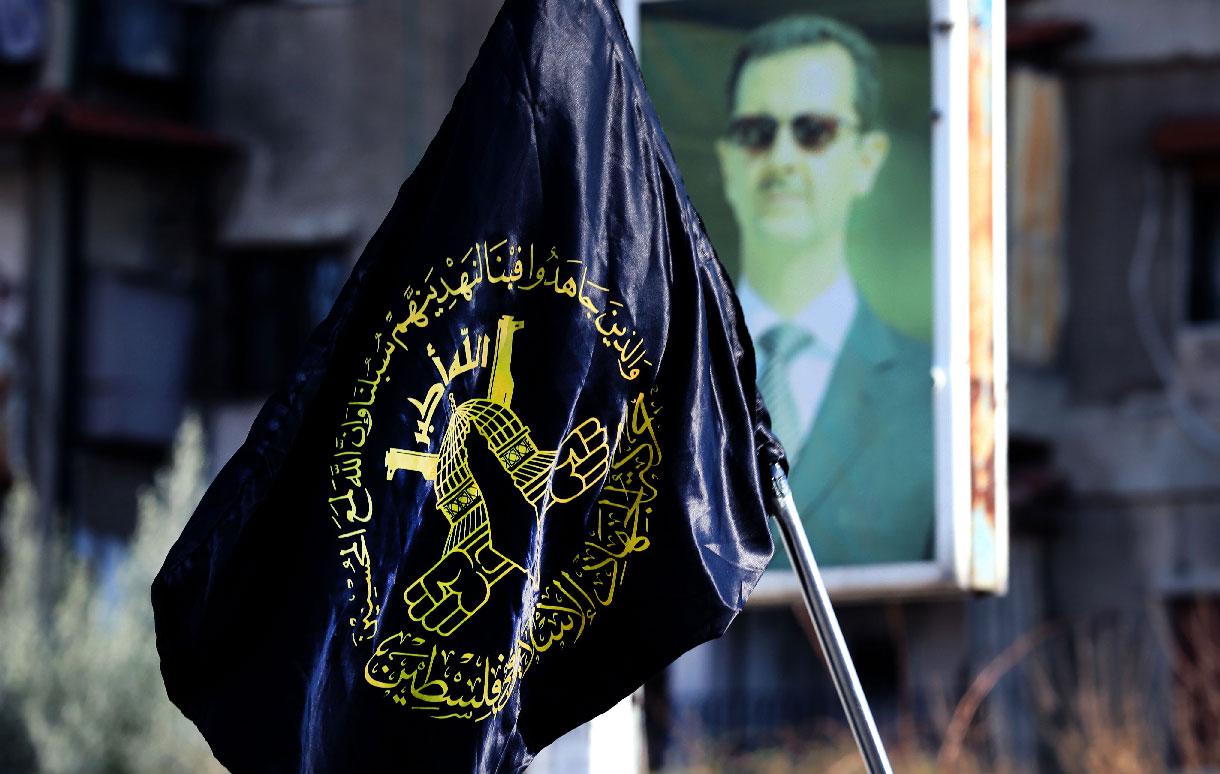 Mourners carry the flag of Islamic Jihad during the funeral of two members at Yarmuk, a Palestinian refugee camp south of Damascus