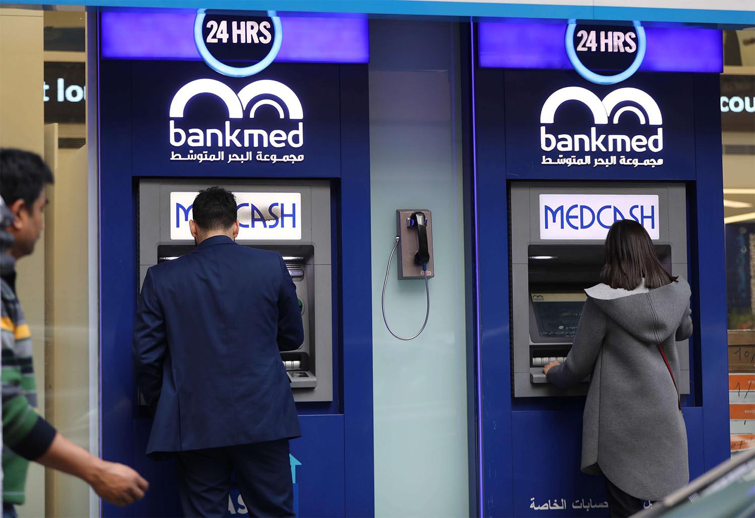 A Lebanese man withdraws money from a ATM in the capital Beirut 