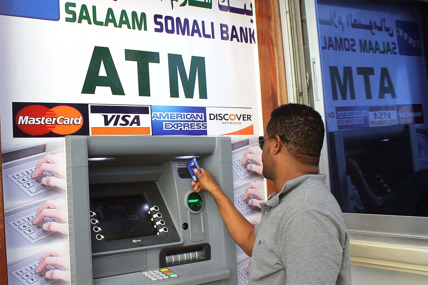 A Somali man uses the first-ever ATM cash withdrawal machine installed in Mogadishu