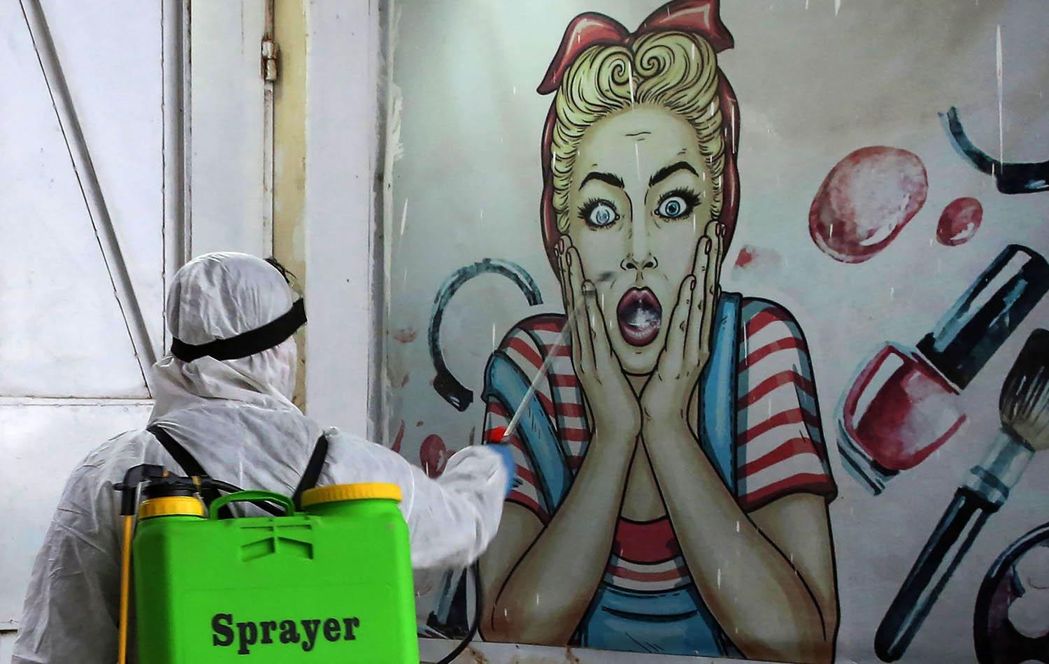 عامل من الصحة يرش حيطان بغداد بالمطهرات