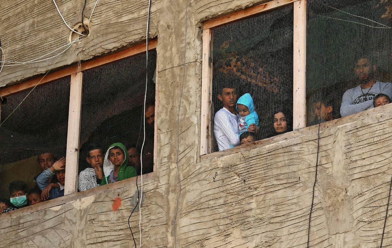 Syrian refugees pictured in a building under construction they have been using as a shelter in Sidon, Lebanon