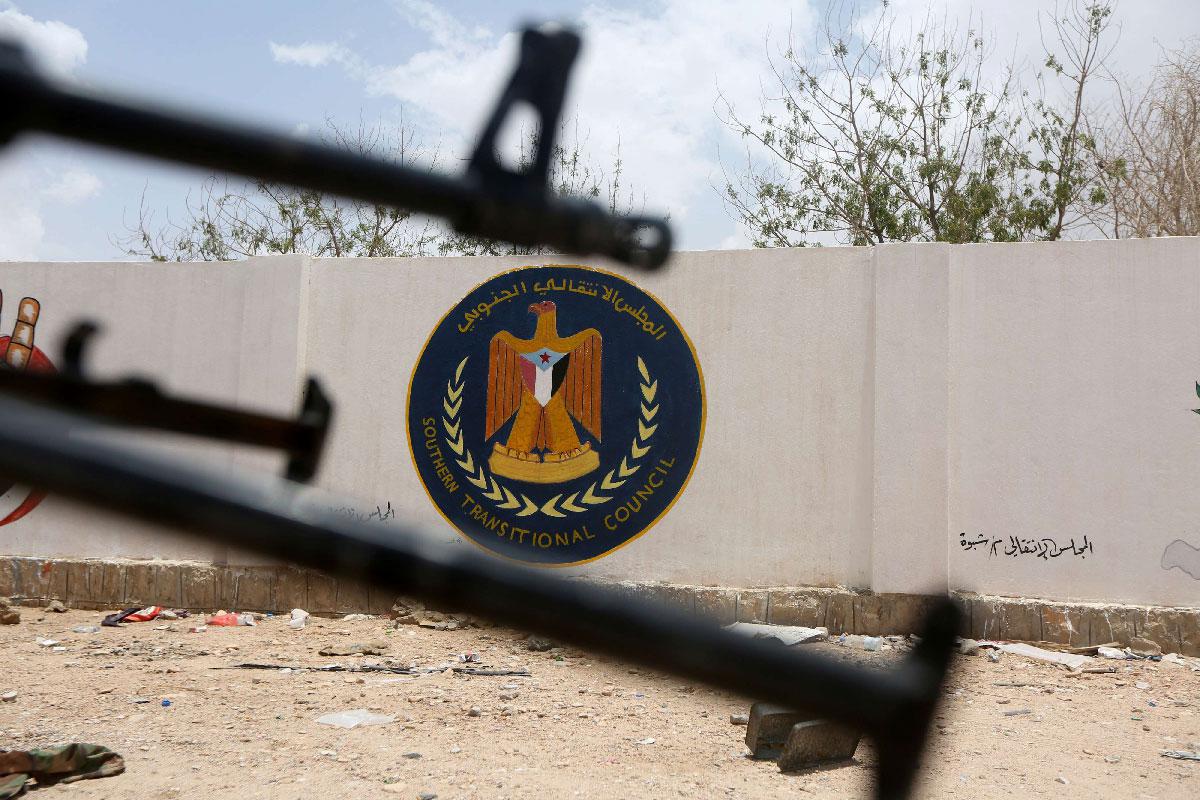 The emblem of the STC is seen between weapons held by Yemeni government soldiers