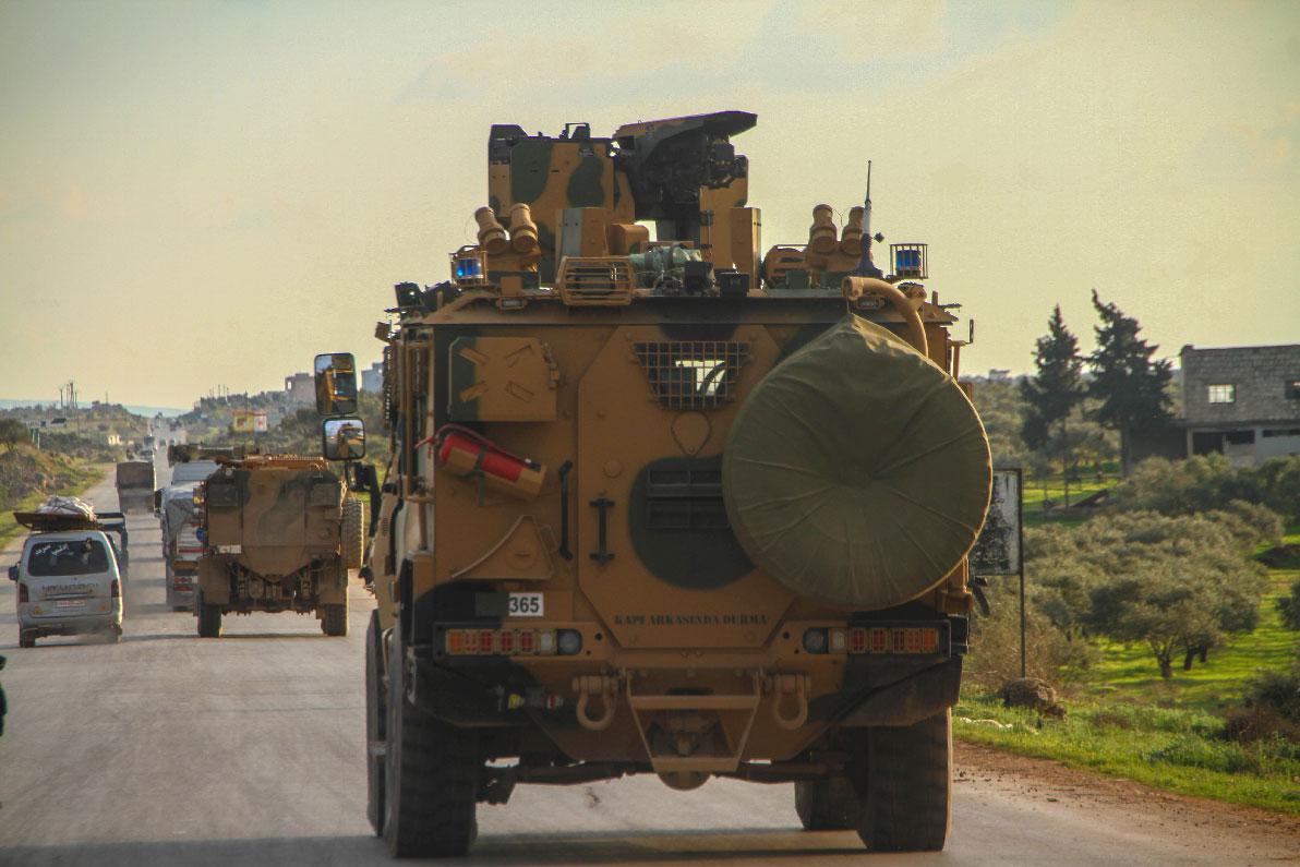 A Turkish military convoy drives along the M4 highway in northern Syria