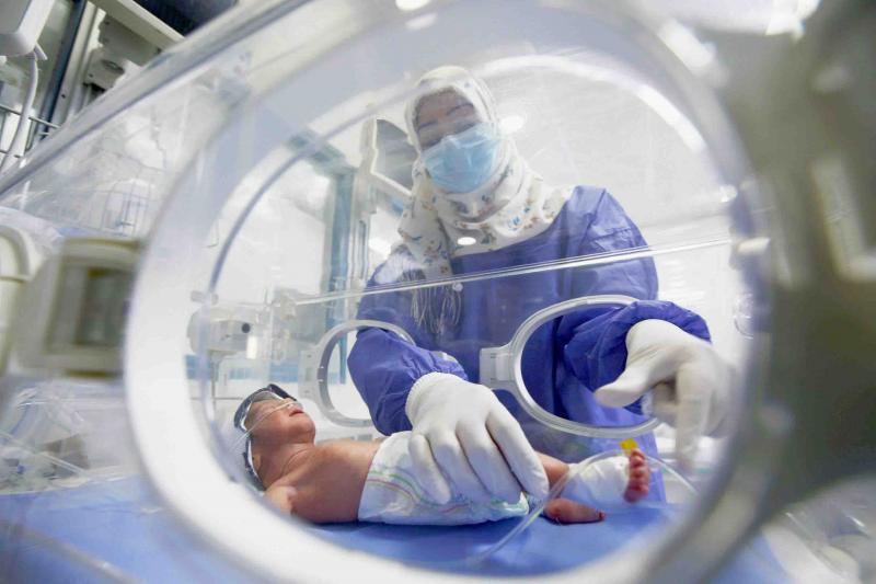 A nurse cares for a new-born baby in a maternity room incubator, in Najaf, Iraq