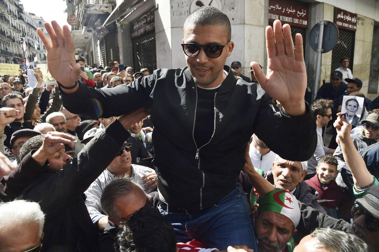 Algerian protesters carrying journalist Khaled Drareni on their shoulders