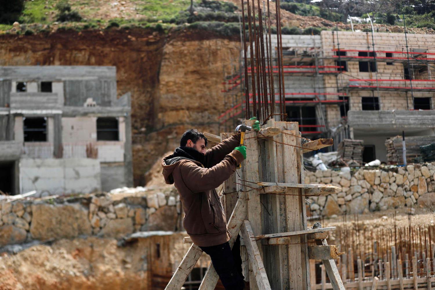 فلسطيني يعمل في بناء مستوطنة اسرائيلية في الضفة الغربية