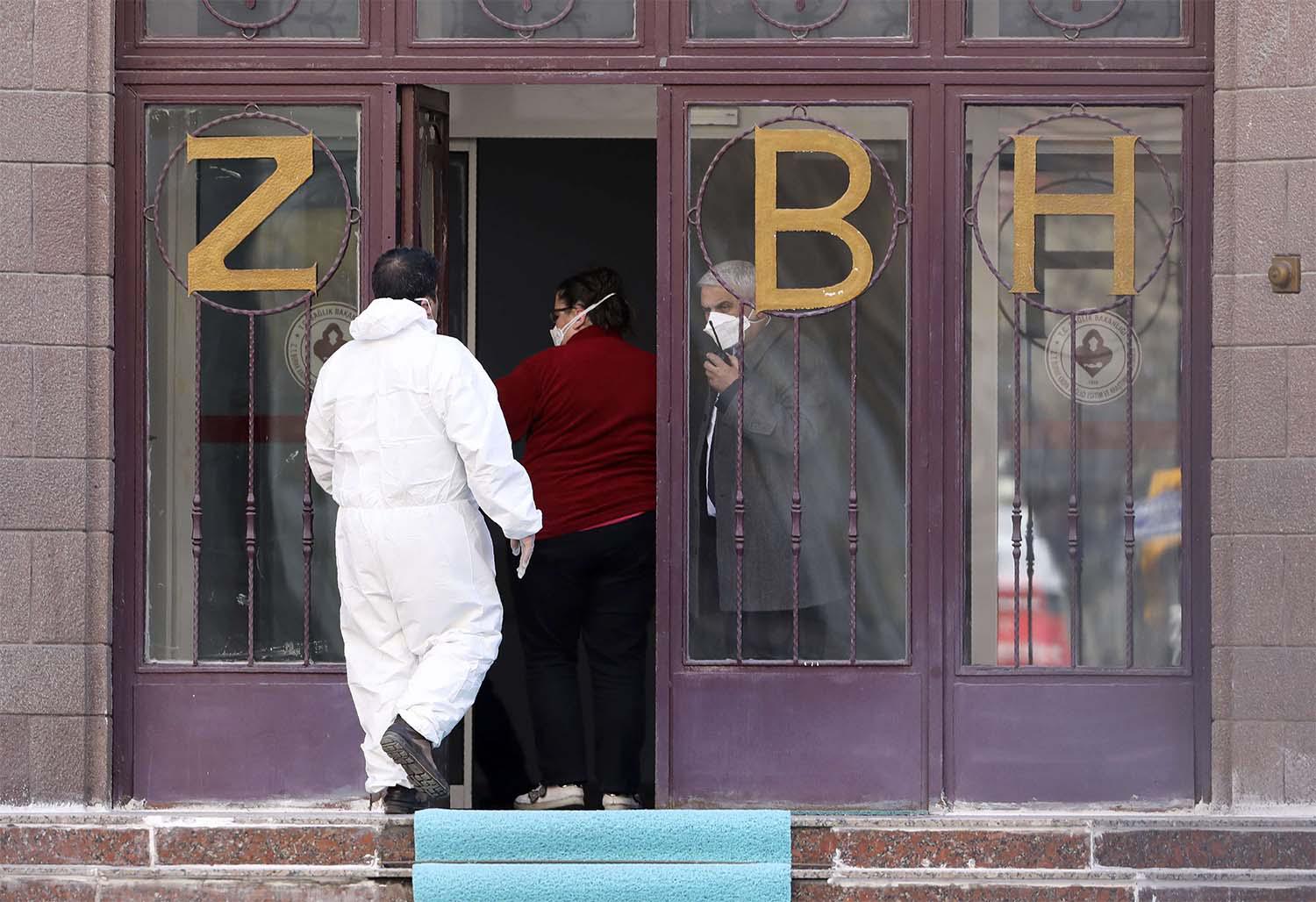 A medical expert in special gear stands at the entrance of Zekai Tahir Burak Hospital in Istanbul