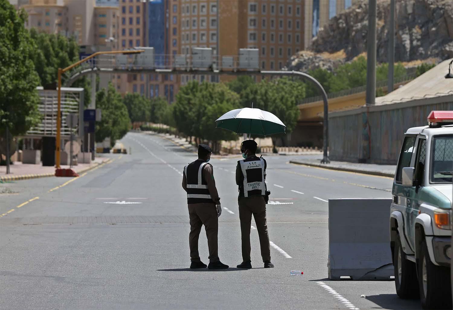 Police officers man a checkpoint in a street in Saudi Arabia's holy city of Mecca