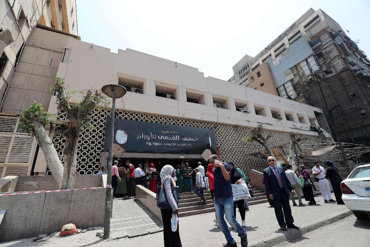 Egyptians walk outside the National Cancer Institute in the capital Cairo