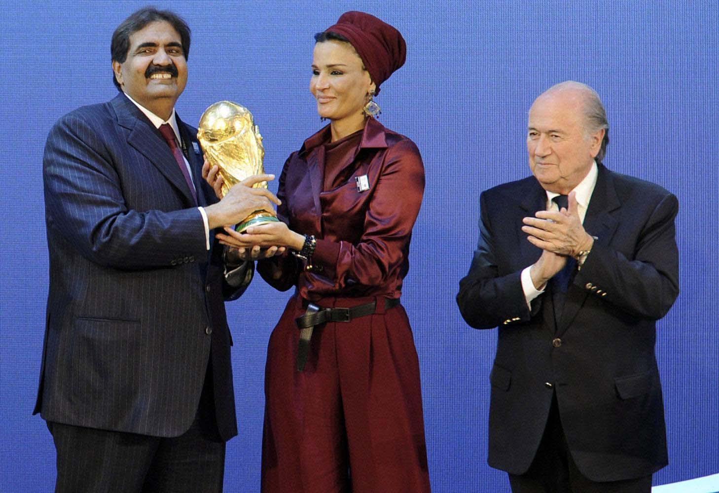 Former Qatari emir holding the world cup with his wife