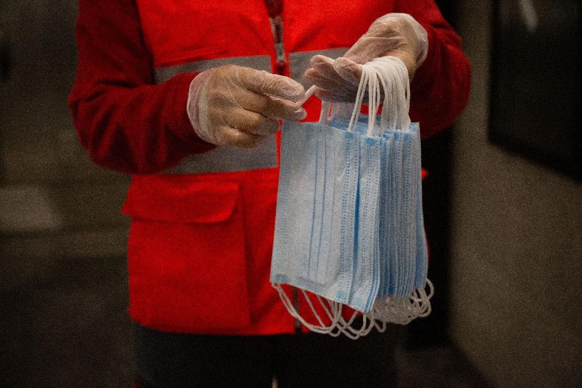 A Red Cross volunteer holds face masks for protection against the coronavirus