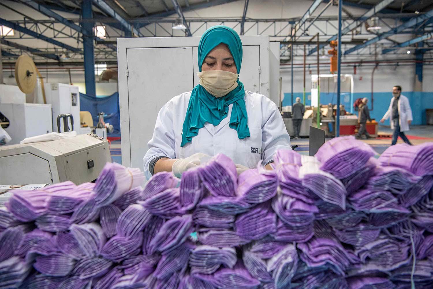 A factory worker packages disposable protective masks along a production line in Morocco's Casablanca 