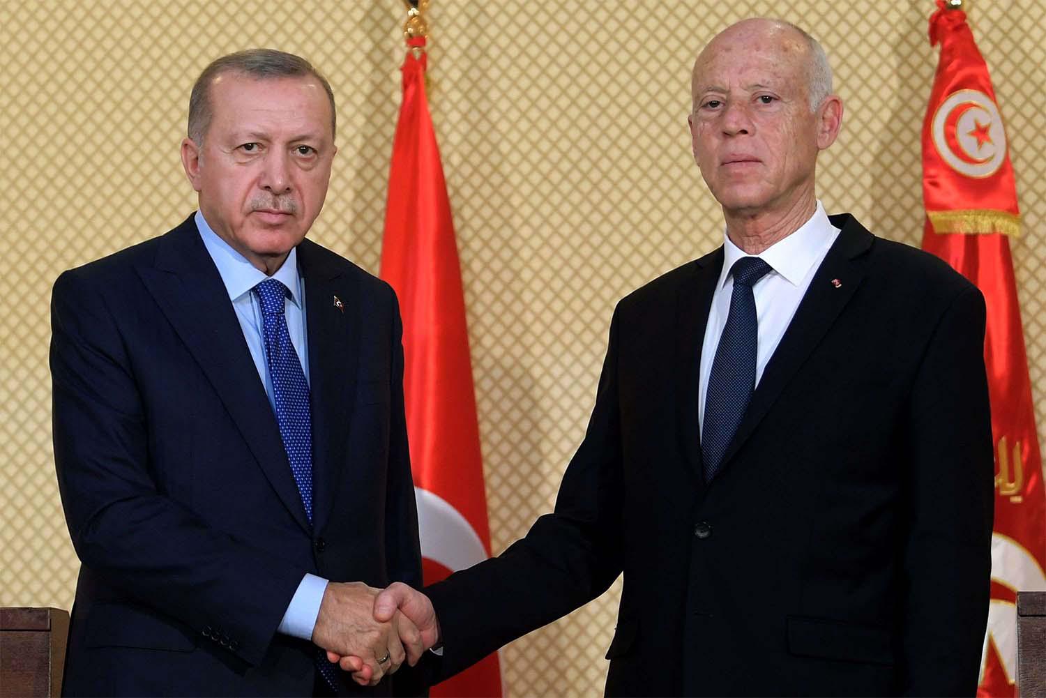 Tunisian President Kais Saied (R) shakes hands with Turkish President Recep Tayyip Erdogan during a joint press conference at the presidential palace in Carthage in December 2019