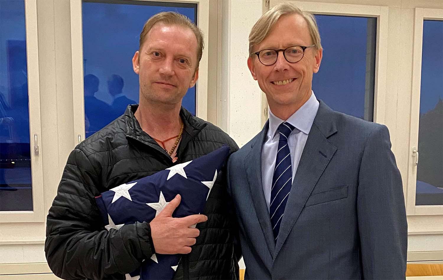 Michael White, a freed US Navy veteran detained in Iran since 2018, poses with US Special Envoy Brian Hook