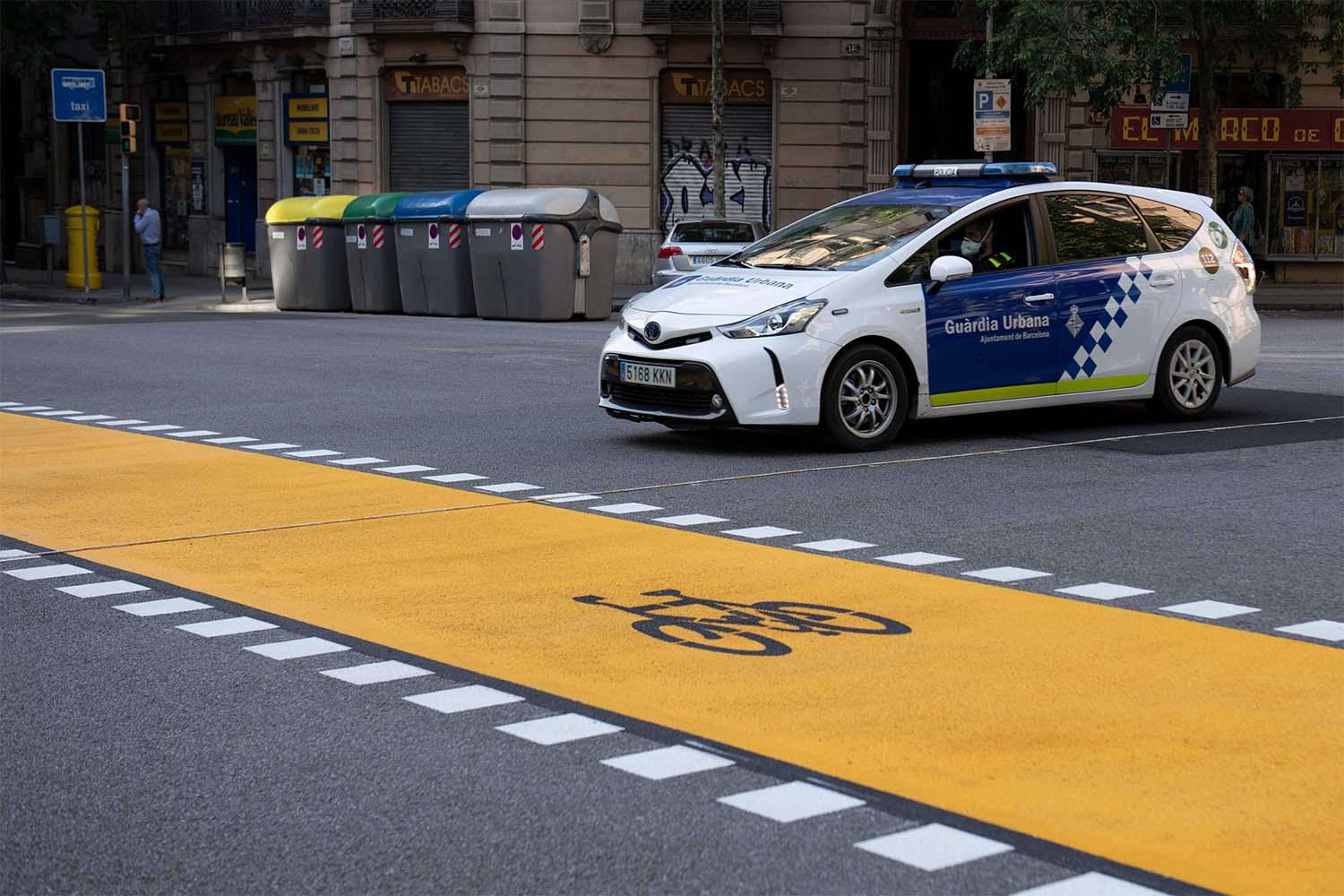 A local police car drives in Barcelona