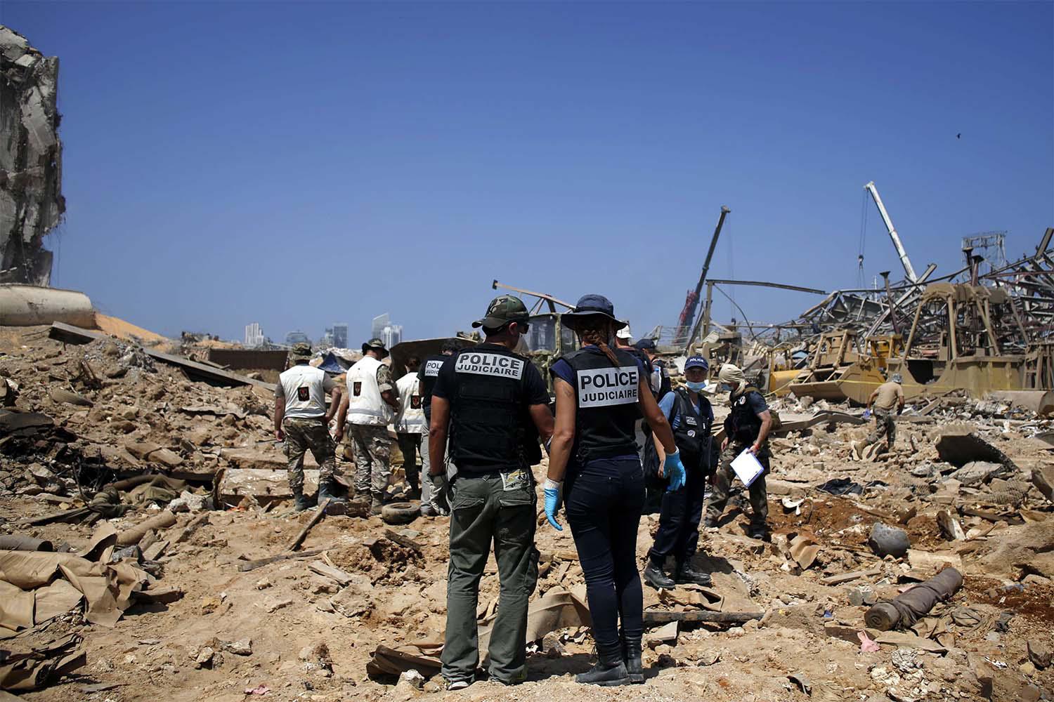 French criminal police officers work on the site of the massive explosion in the port of Beirut