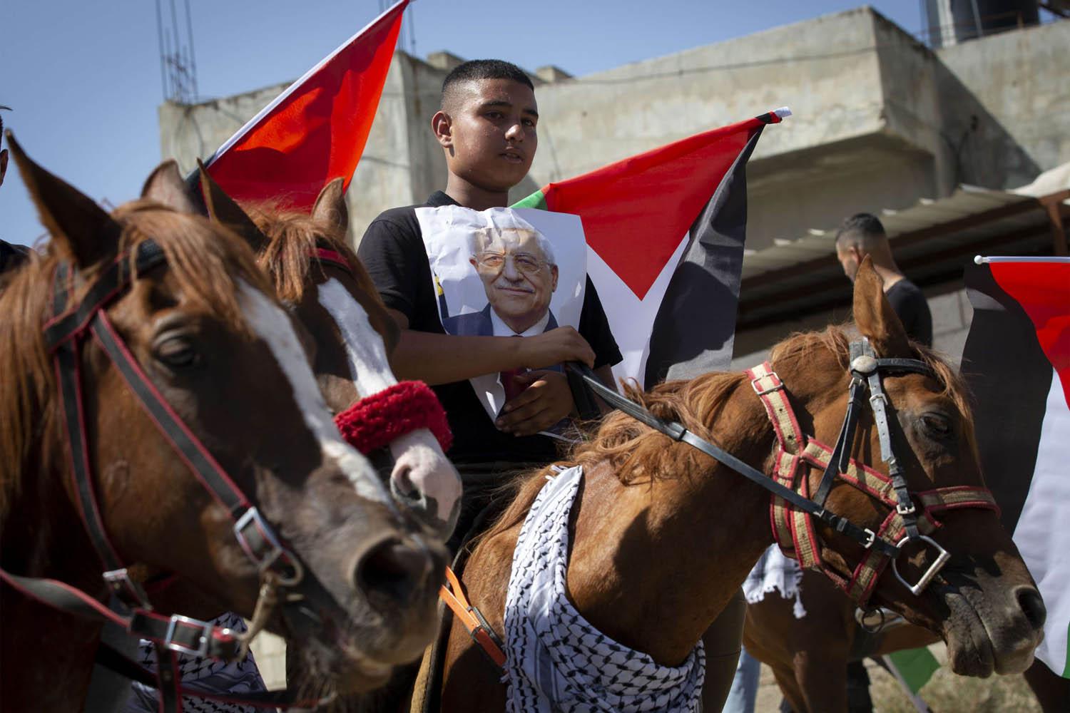 صبي فلسطيني يرفع صورة الرئيس محمود عباس