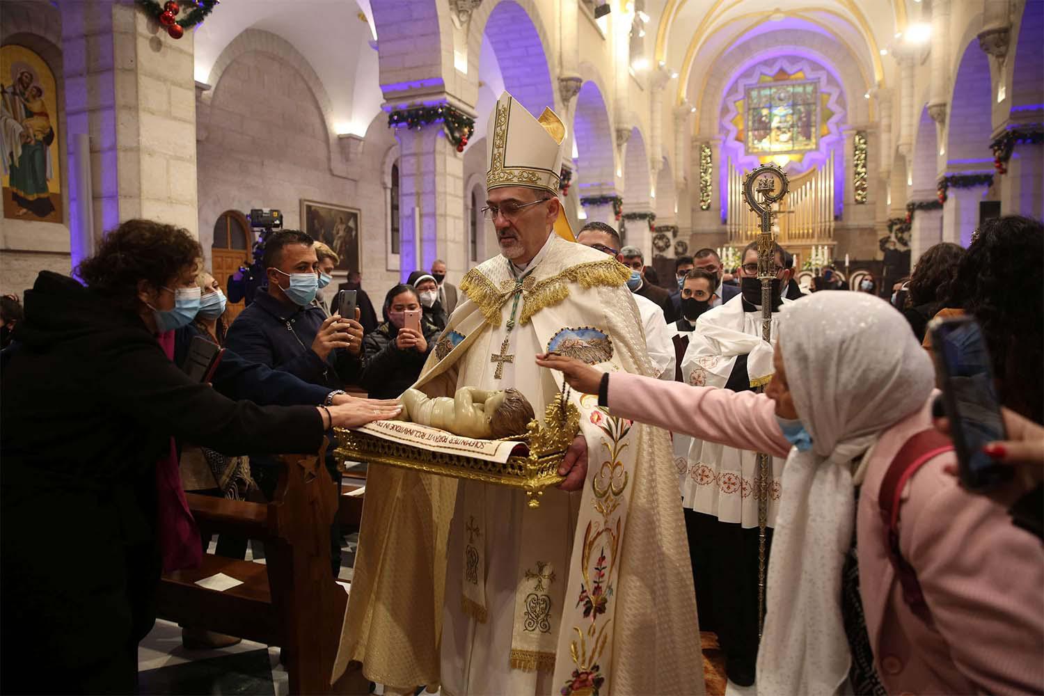 Apostolic Administrator of the Latin Church in the Holy land Pierbattista Pizzaballa (C), leads a Christmas midnight mass at the Church of the Nativity in Bethlehem