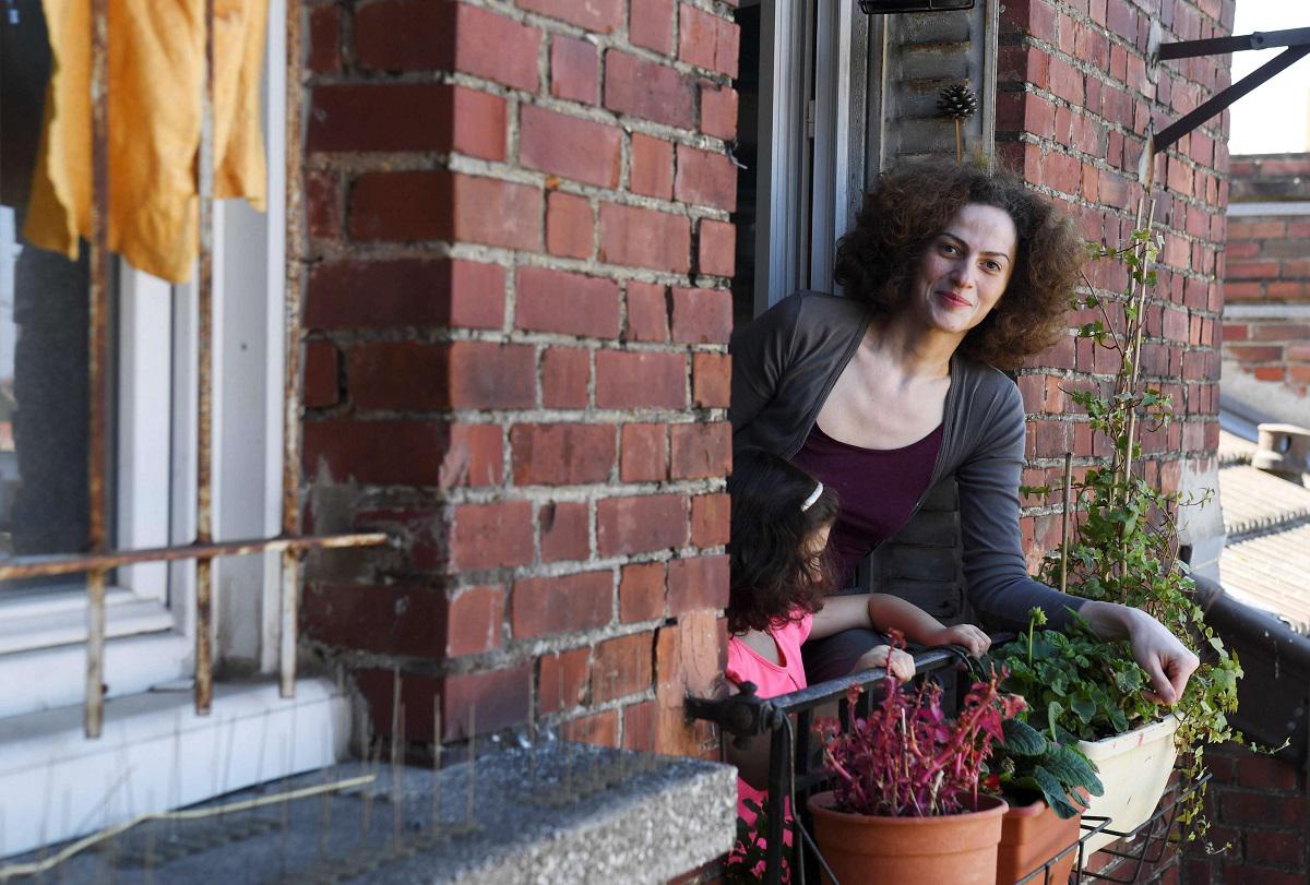 لاجئة سورية تطل من نافذة منزلها في باريس