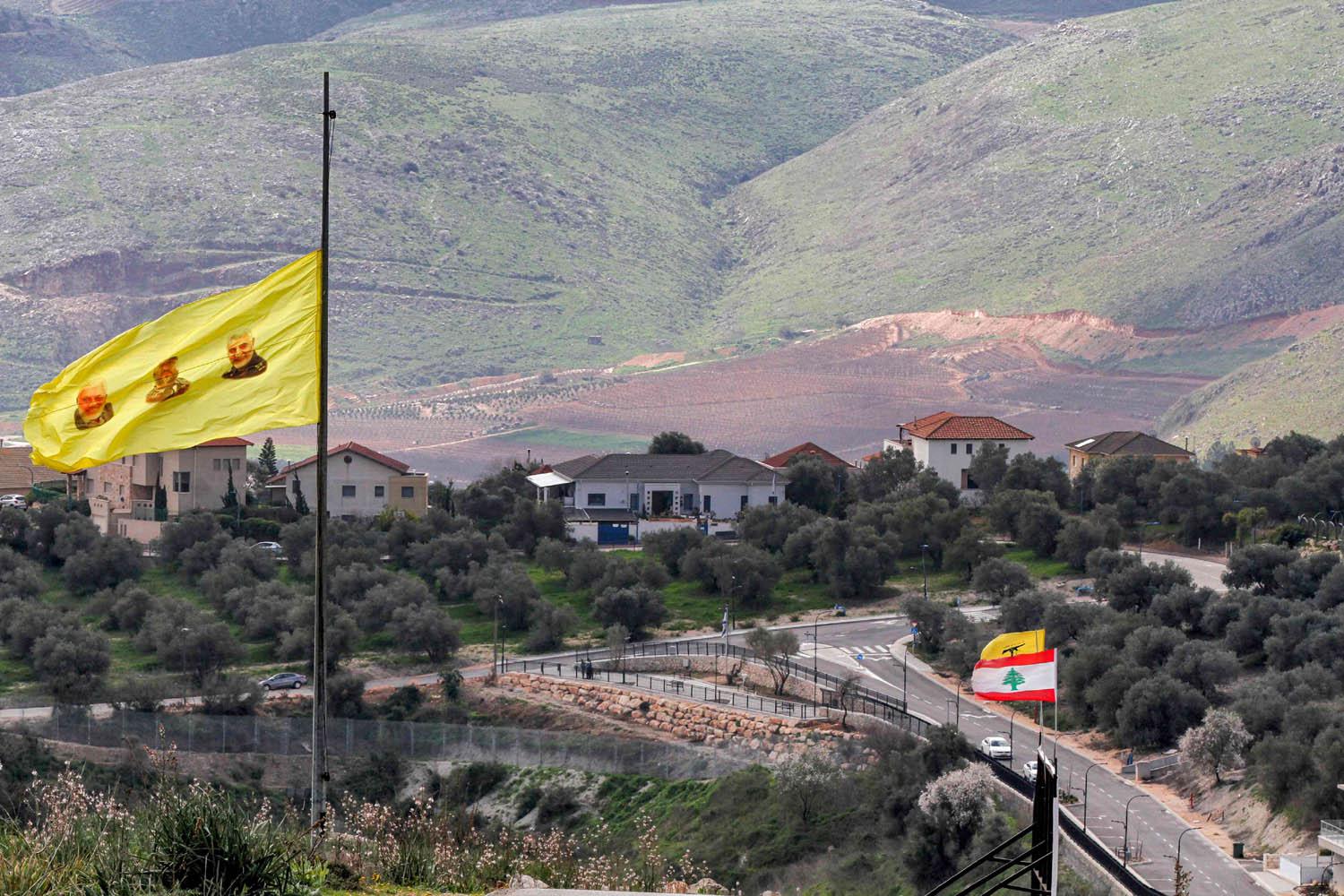 صور لسليماني والمهندس ومغنية على راية لحزب الله قرب الحدود مع إسرائيل