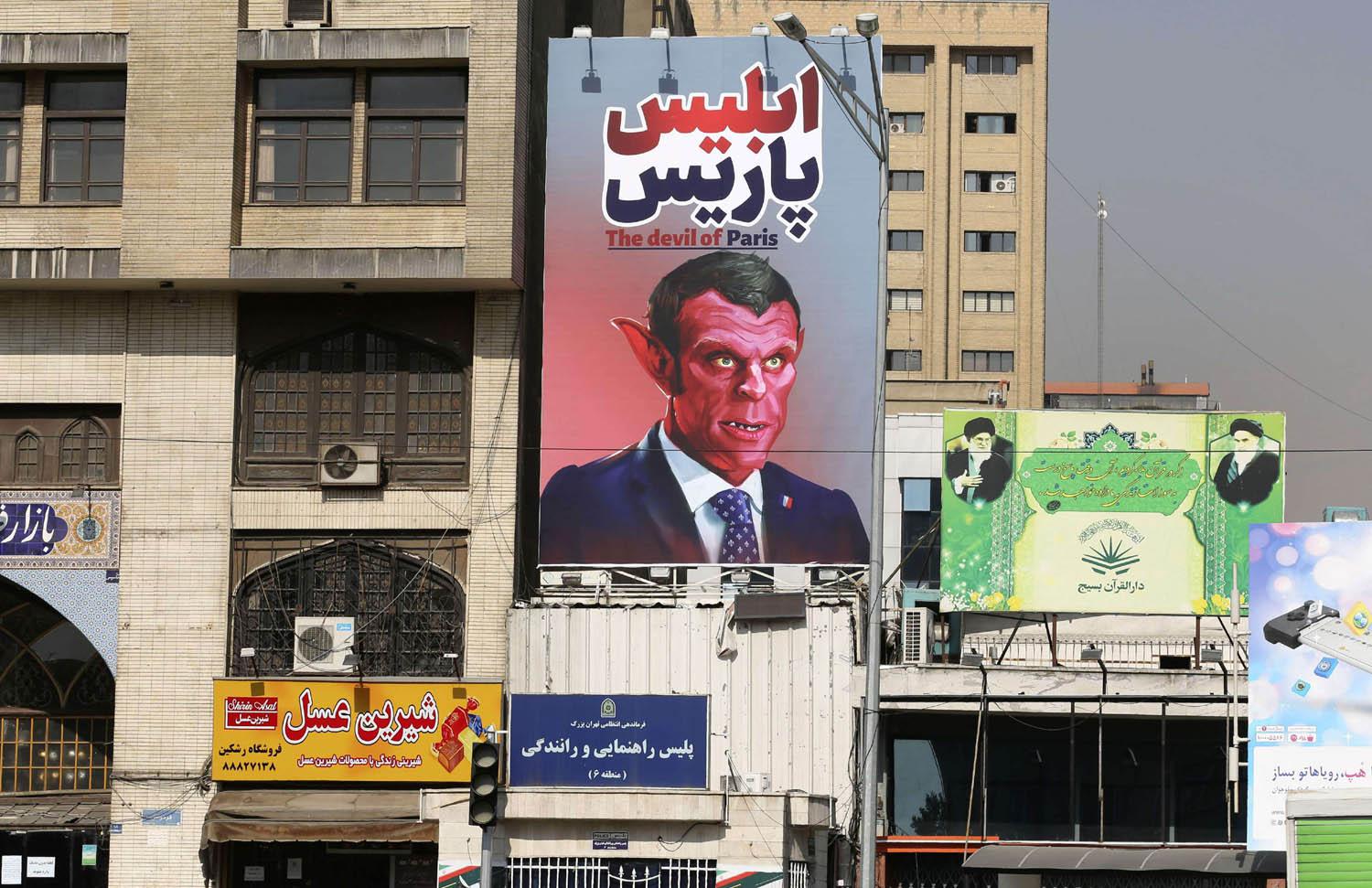 جدارية في طهران تصور الرئيس الفرنسي ايمانويل ماكرون كشيطان