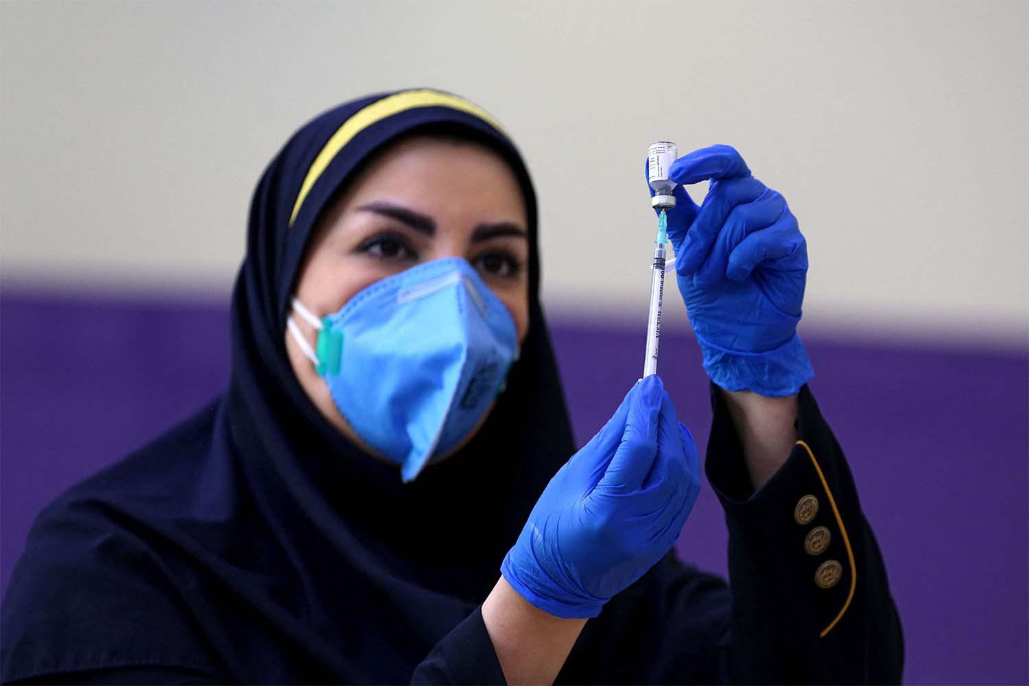 Iranian health worker prepares an injection of the locally-made COVID-19 vaccine