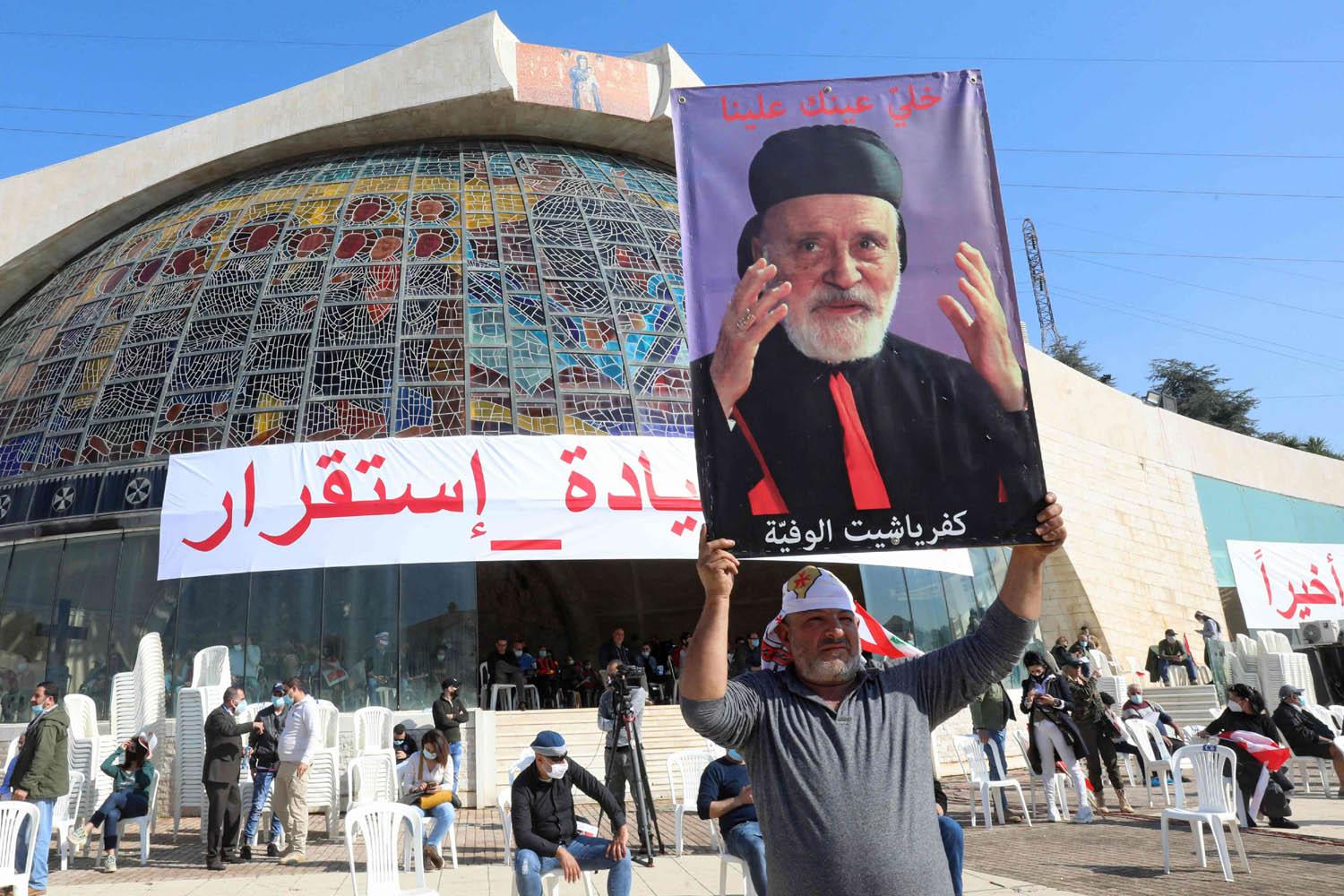 لبناني يرفع صورة الكاردينال الراحل نصرالله صفير قبل قداس وكلمة من رئيس الكنيسة اللبنانية بشارة الراعي