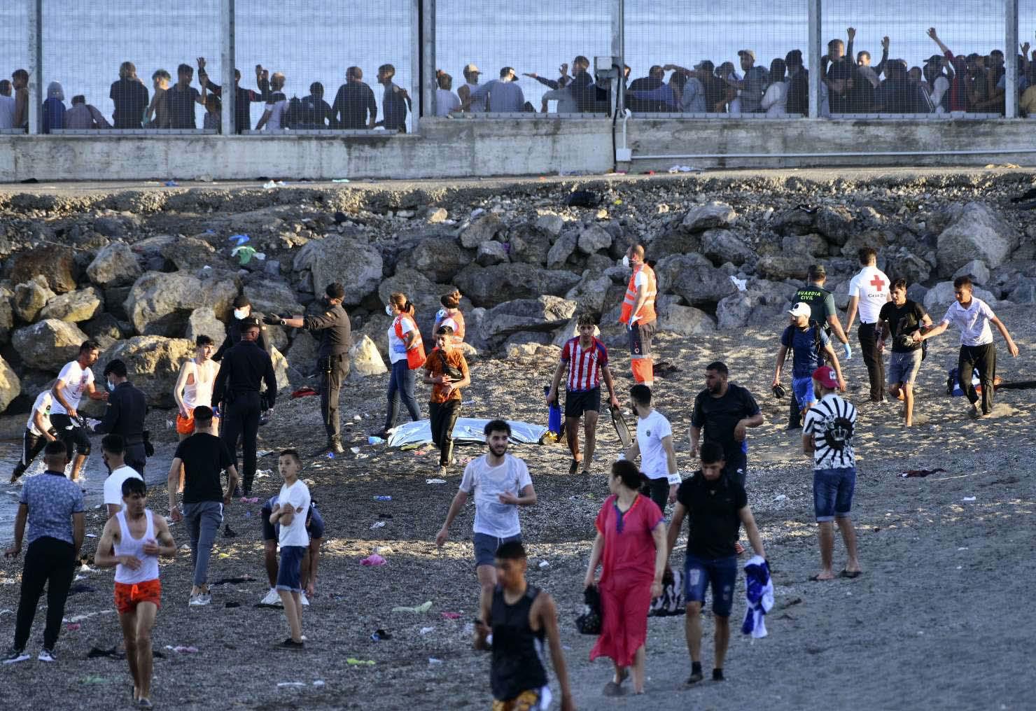 Spanish Guardia Civil officers try to stop people from Morocco entering into Ceuta