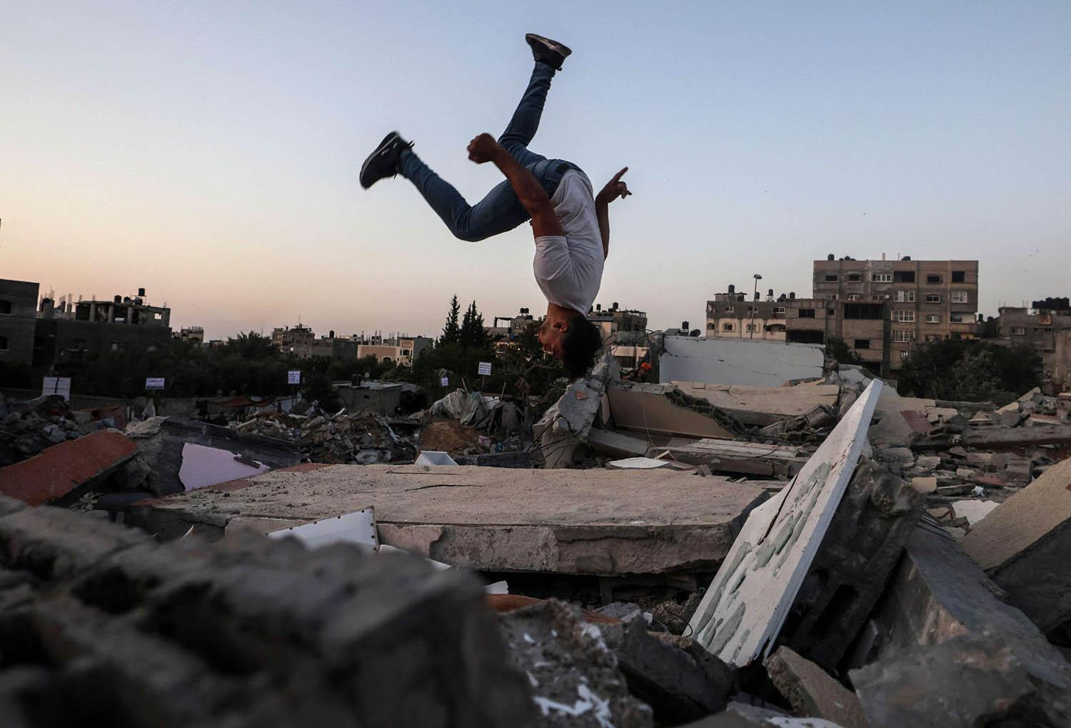 طفل فلسطيني يلعب على اطلال مبان مهدمة بالقصف في غزة