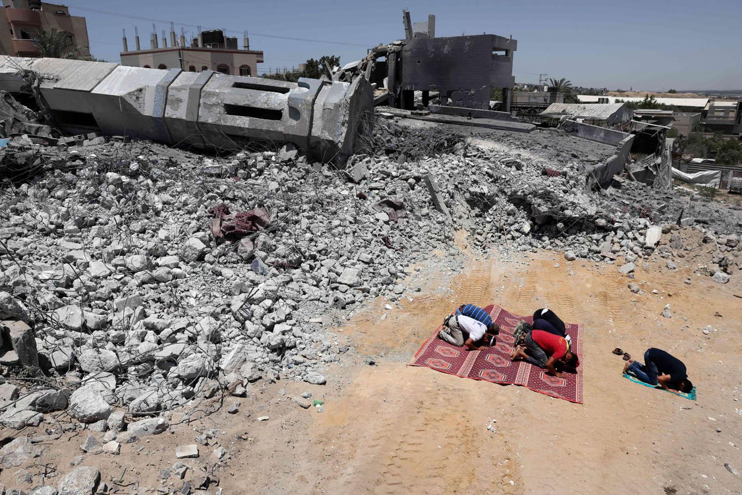 فلسطينيون يصلون أمام أطلال جامع في غزة دمره القصف الاسرائيلي