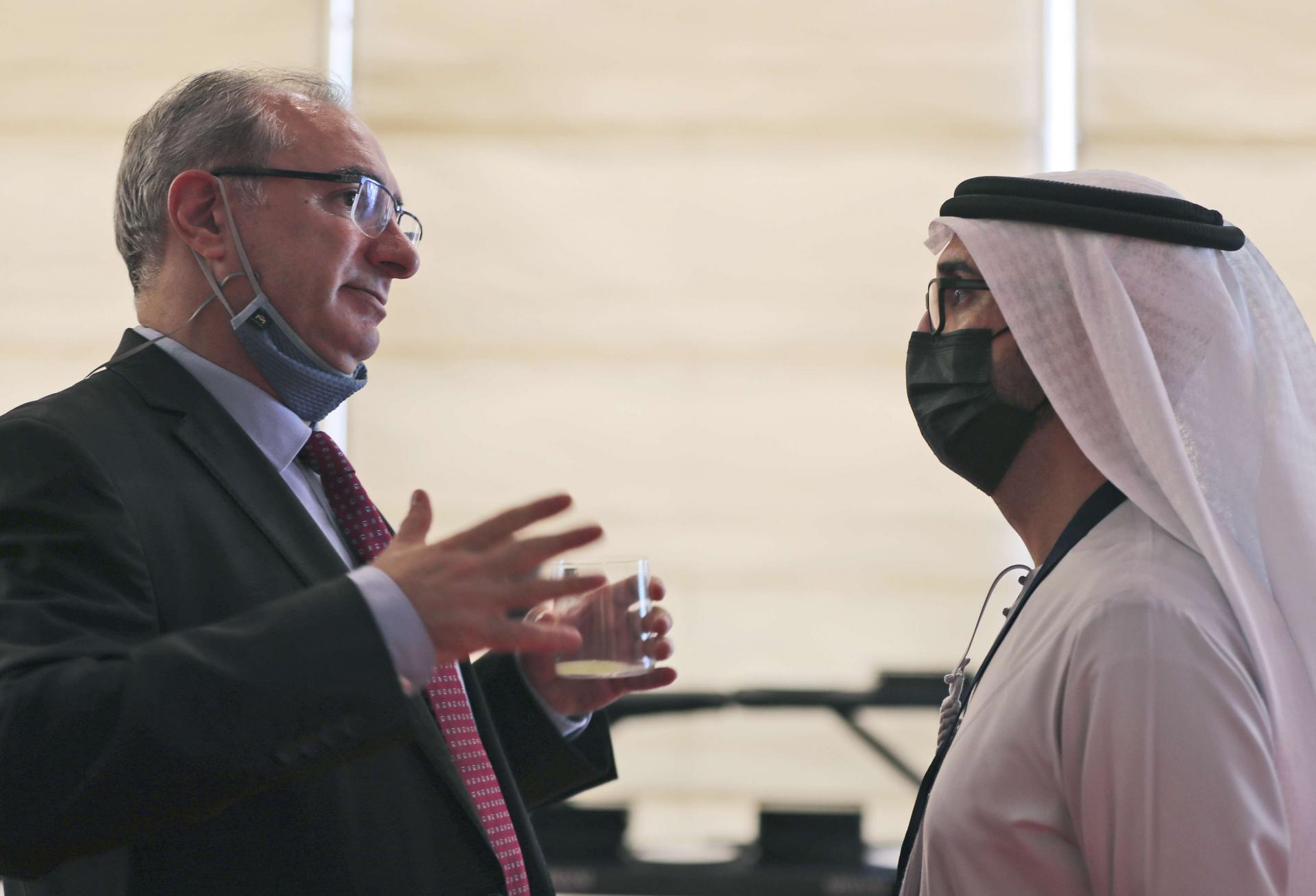 سفير إسرائيل في الإمارات إيتان نائيه (يسار) يتحدث مع مسؤول إماراتي خلال منتدى الاستثمار العالمي في دبي 