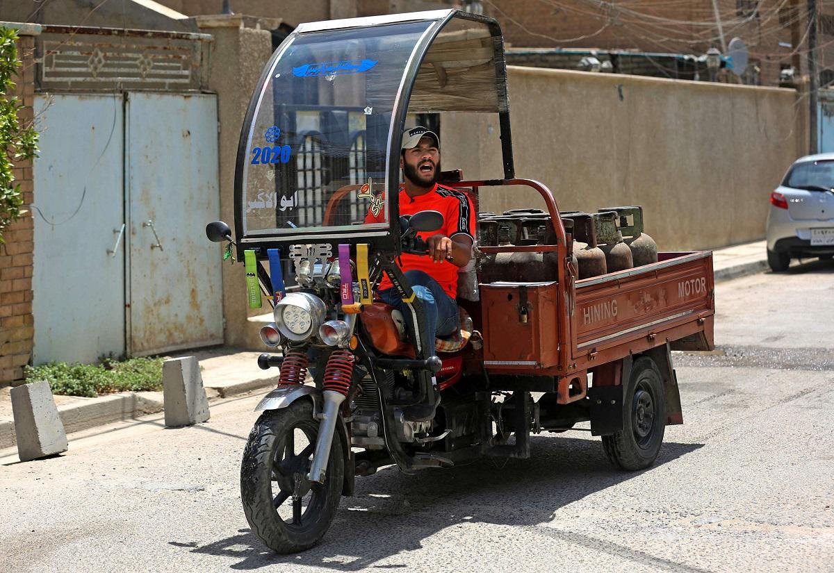 الشاب العراقي منتظر عباس يتنقل على عربة مثبتة الى دراجة نارية 