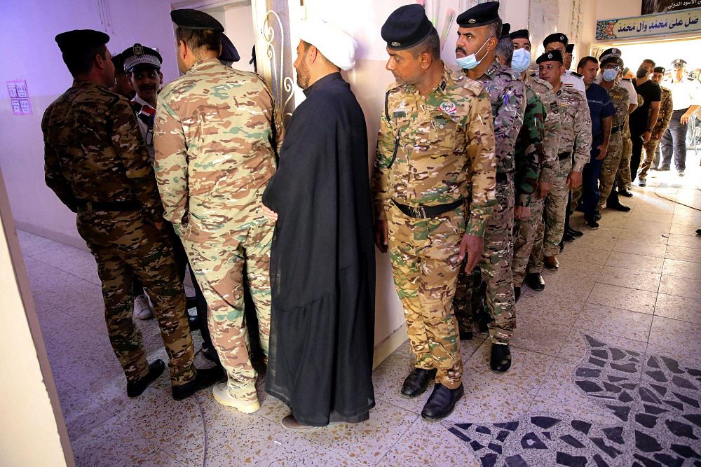 شوهد العشرات من طلاب الكلية العسكرية يقفون بالصف داخل مدرسة للتصويت